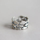Bague Poissons Triple Ajustable en argent, formée de plusieurs poissons ajourés qui créent un anneau large et ajustable.