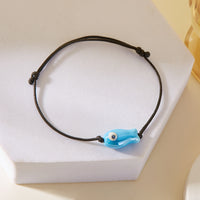 Bracelet Poisson Bleu Ajustable, posé sur un support, mettant en évidence le pendentif poisson en céramique.