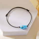 Bracelet Poisson Bleu Ajustable, posé sur un support, mettant en évidence le pendentif poisson en céramique.