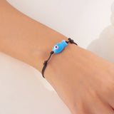 Gros plan sur le Bracelet Poisson Bleu Ajustable, soulignant la forme minimaliste du pendentif et sa finition brillante