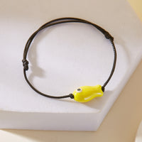 Gros plan sur le Bracelet Poisson Jaune Ajustable, posé sur un support, montrant le poisson en céramique.