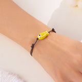 Bracelet Poisson Jaune Ajustable porté au poignet, mettant en valeur le pendentif poisson de couleur vive.