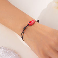Gros plan sur le Bracelet Poisson Rouge Ajustable, montrant le design minimaliste et la finition brillante du pendentif.