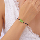 Bracelet Poisson Vert Ajustable, soulignant le cordon noir et la teinte vive du poisson