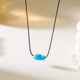 Gros plan sur le Collier Poisson Bleu sur Cordon Ajustable, illustrant la couleur éclatante du pendentif poisson.
