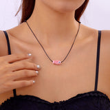 Collier Poisson Rose sur Cordon Ajustable, porté autour du cou, mettant en avant le pendentif minimaliste en forme de poisson.