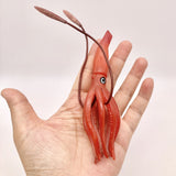 Figurine Calamar Rouge présentée dans une main, permettant d’apprécier sa taille et sa forme élancée.