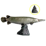 Figurine Poisson Alligator Gar en résine, avec un aspect vert métallique et un long museau, présentée sur un socle rocheux.
