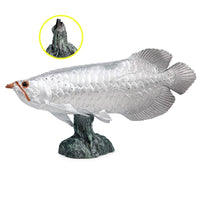 Figurine Poisson Arowana Argenté en résine, posée sur un socle rocheux.

