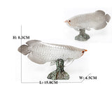 Figurine Poisson Arowana Argenté en résine, mesurant environ 15,8 cm de long, 4,5 cm de large et 8,3 cm de haut, présentée sur un socle rocheux.
