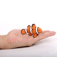 Figurine Poisson Clown Orange – Amphiprion Percula montrée dans la main, mettant en évidence sa taille et ses bandes blanches bordées de noir.
