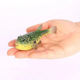 Figurine Poisson Globe Vert en résine, montrée dans la main pour illustrer sa taille, avec un motif vert tacheté et un ventre jaune.
