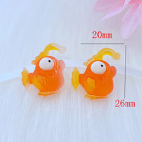 Deux figurines Poisson Lanterne Orange en résine, mesurant environ 26 mm x 20 mm, présentées sur fond blanc pour illustrer leurs dimensions.
