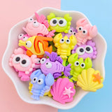 Lot de figurines Poisson Multicolore regroupées dans un petit bol, avec des poissons, crustacés et coquillages en couleurs vives.
