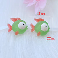 Deux figurines Poisson Vert en Résine, mesurant environ 22 mm x 21 mm, présentées sur un fond blanc pour illustrer leur taille.

