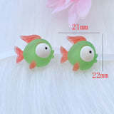 Deux figurines Poisson Vert en Résine, mesurant environ 22 mm x 21 mm, présentées sur un fond blanc pour illustrer leur taille.


