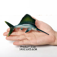Figurine Poisson Voilier tenue dans une main, illustrant ses dimensions de 14 × 2,6 × 5,6 cm.