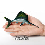 Figurine Poisson Voilier tenue dans une main, illustrant ses dimensions de 14 × 2,6 × 5,6 cm.